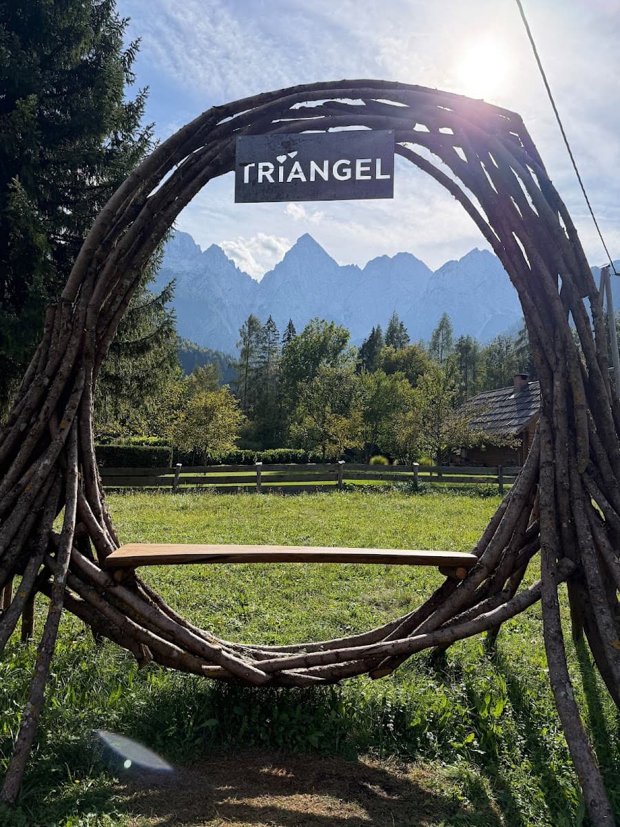 Wooden circular bench with "Triangel" sign framing a mountain landscape view