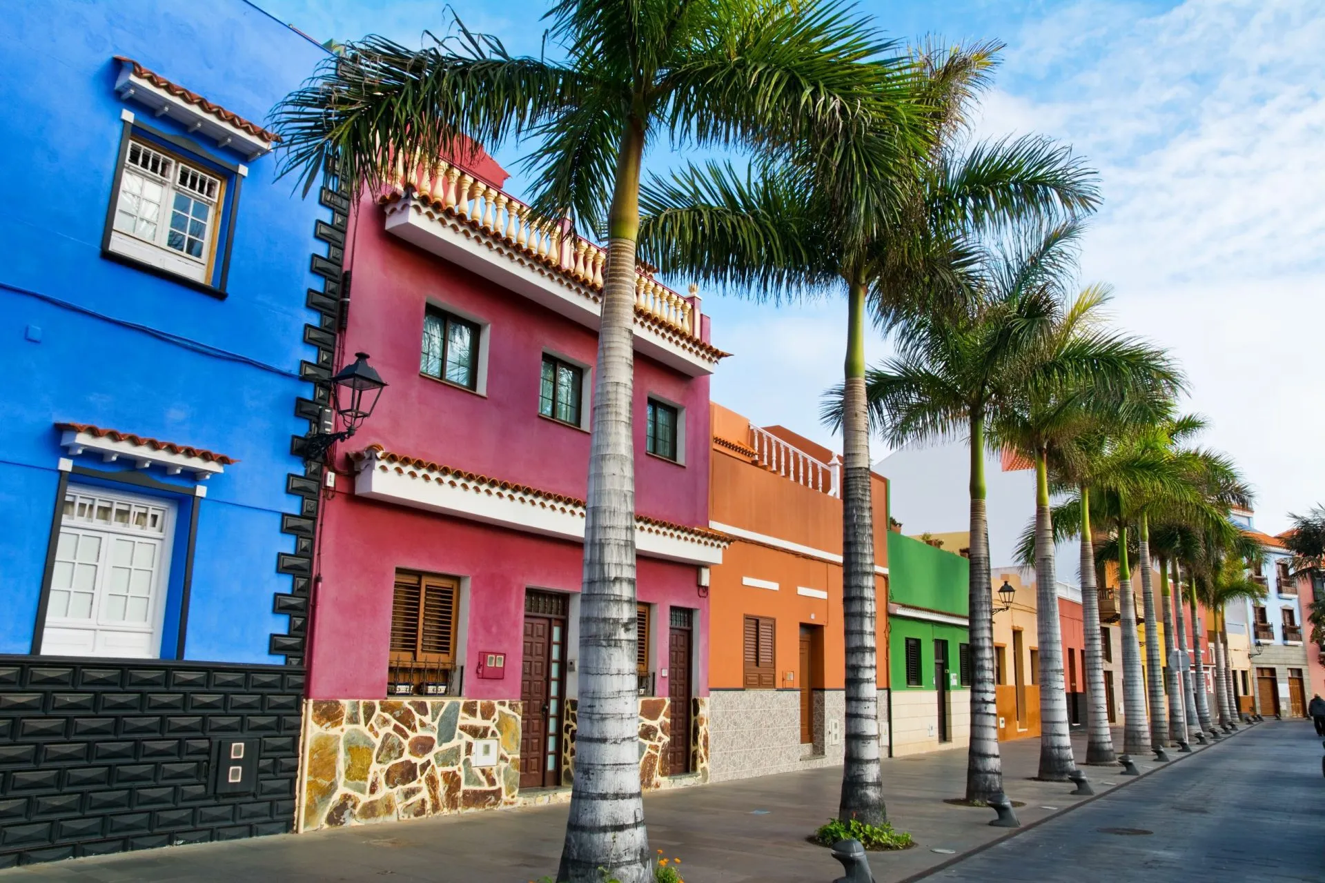 Bunte Häuser und Palmen auf einer Straße in Puerto de la Cruz, Teneriffa, Kanarische Inseln.
