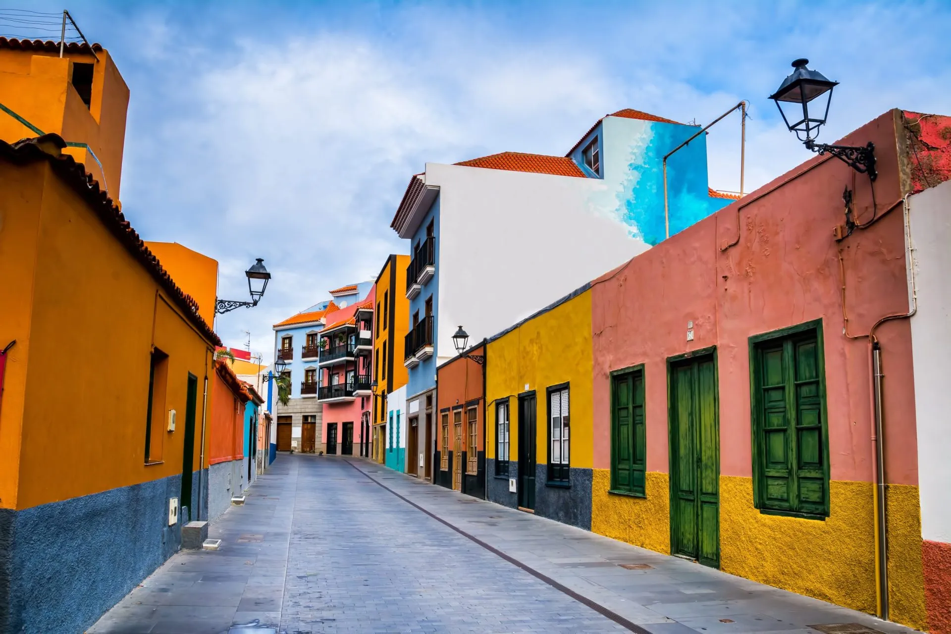 Colourful houses on street in Puerto de la Cruz town, Tenerife, Canary Islands, Spain. This is tourist pedestrian street near the ocean there are many restaurants and stores
